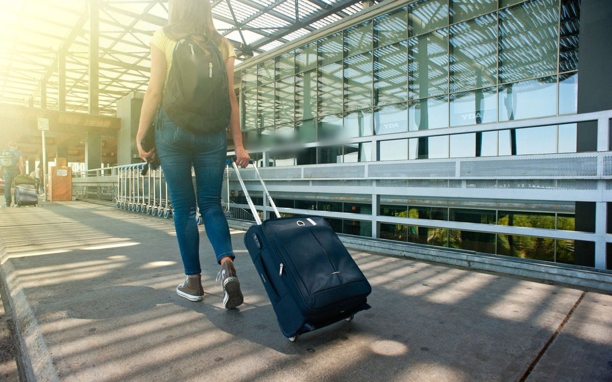 Traveller walking with a carry-on suitcase at the airport