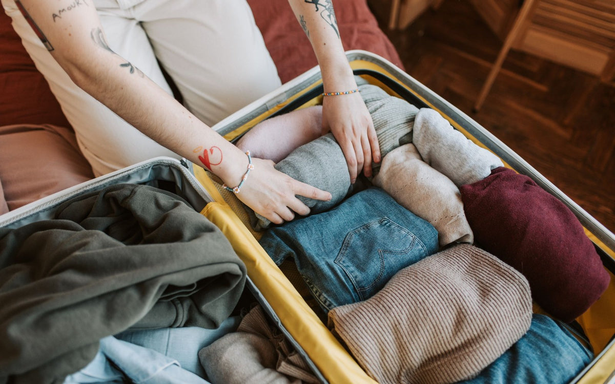 Packing folded clothes into a suitcase
