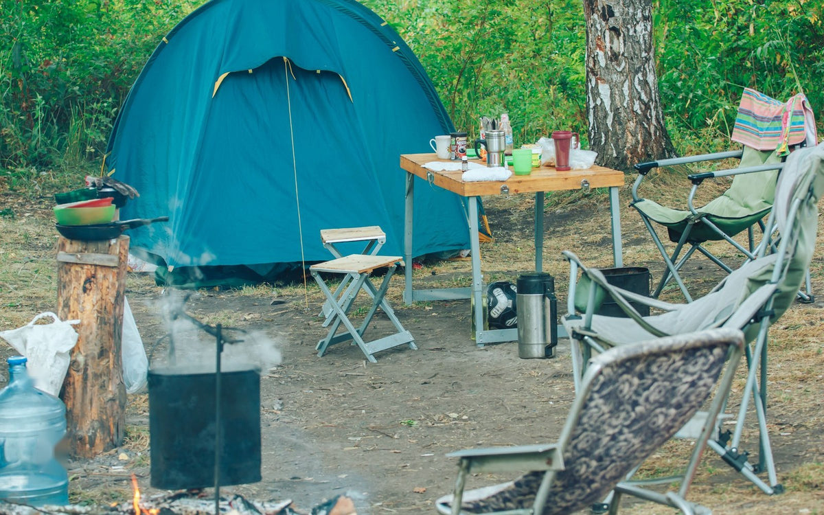 Campsite with a tent, folding chairs and camp kitchen