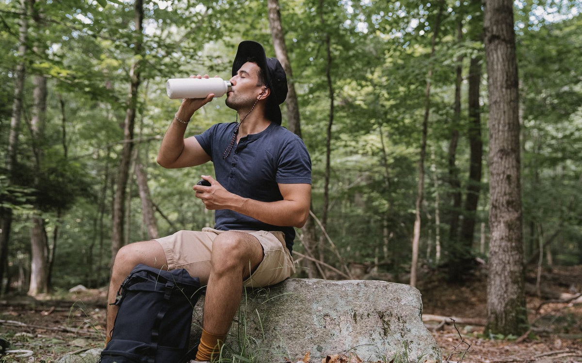 Hiker drinking water during a break in the forest